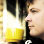 Young man drinking coffee outside
